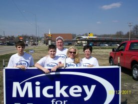 Mickey with family putting up signs for the upcoming election.